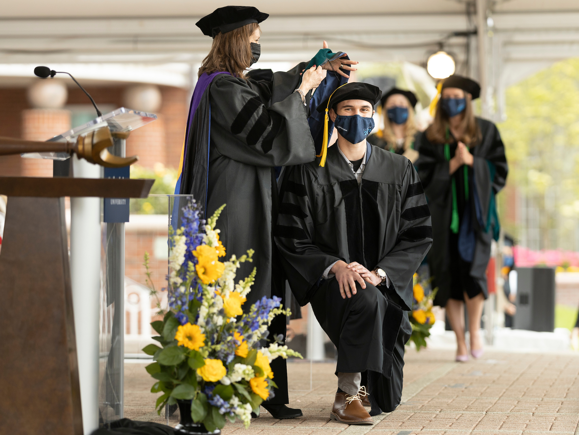 Student smiling while getting his hood put on