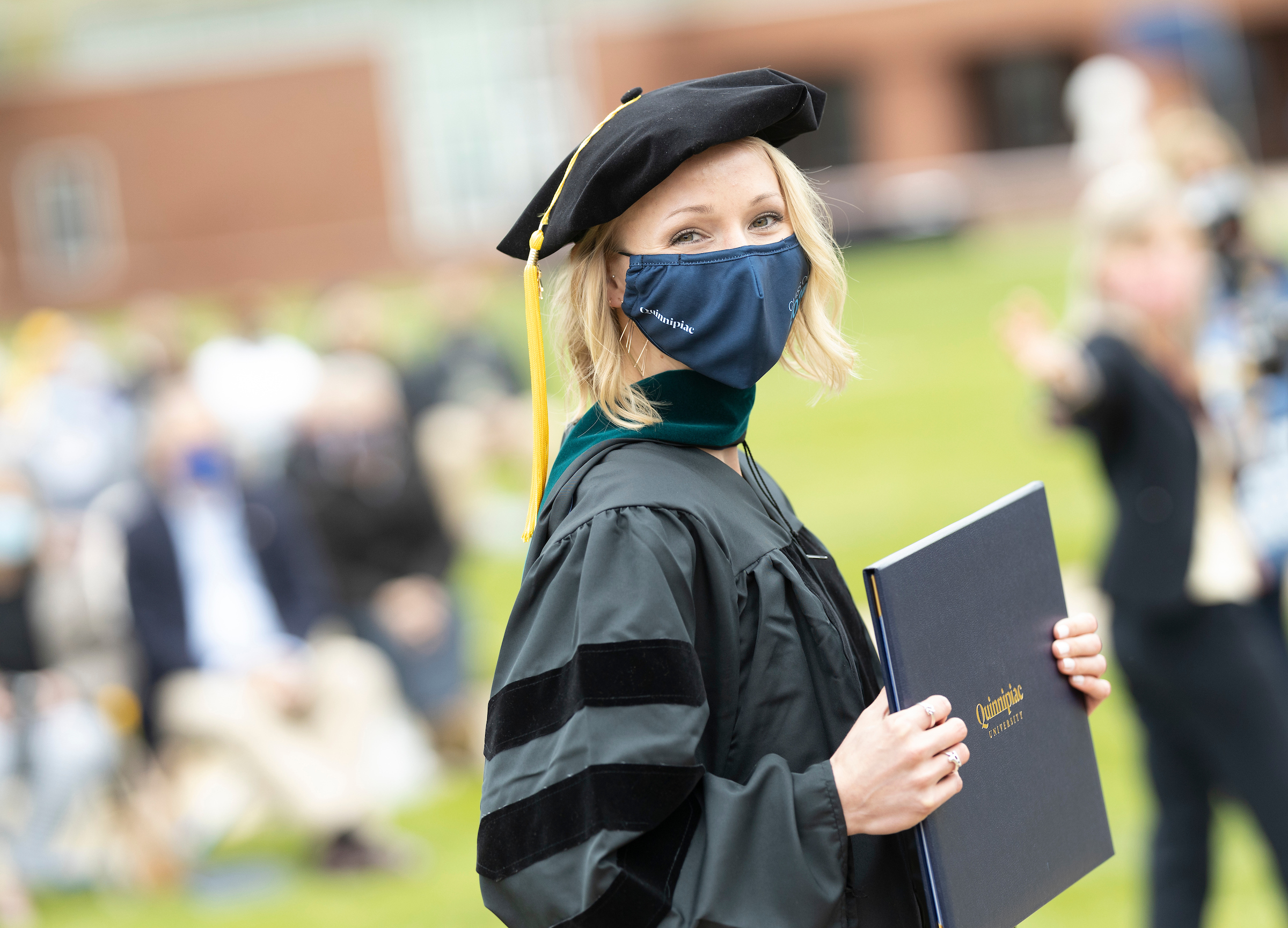 Side profile of student holding diploma
