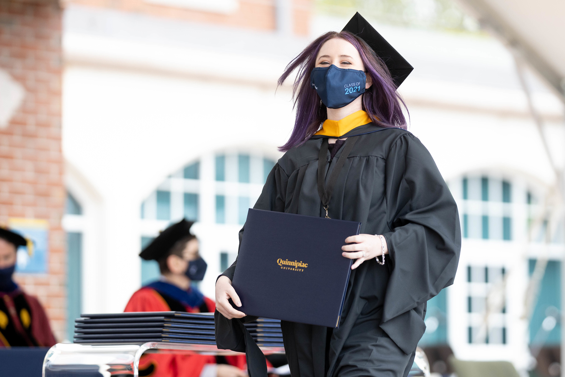 Student walking across stage after receiving diploma