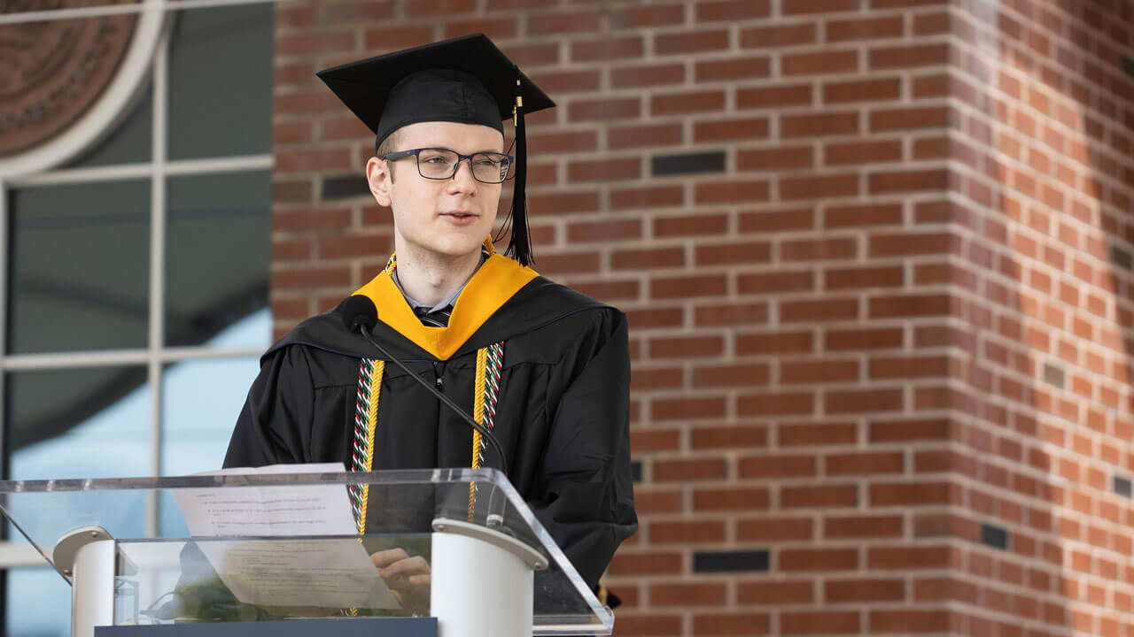 Christian Kearney speaks at the podium on the library steps