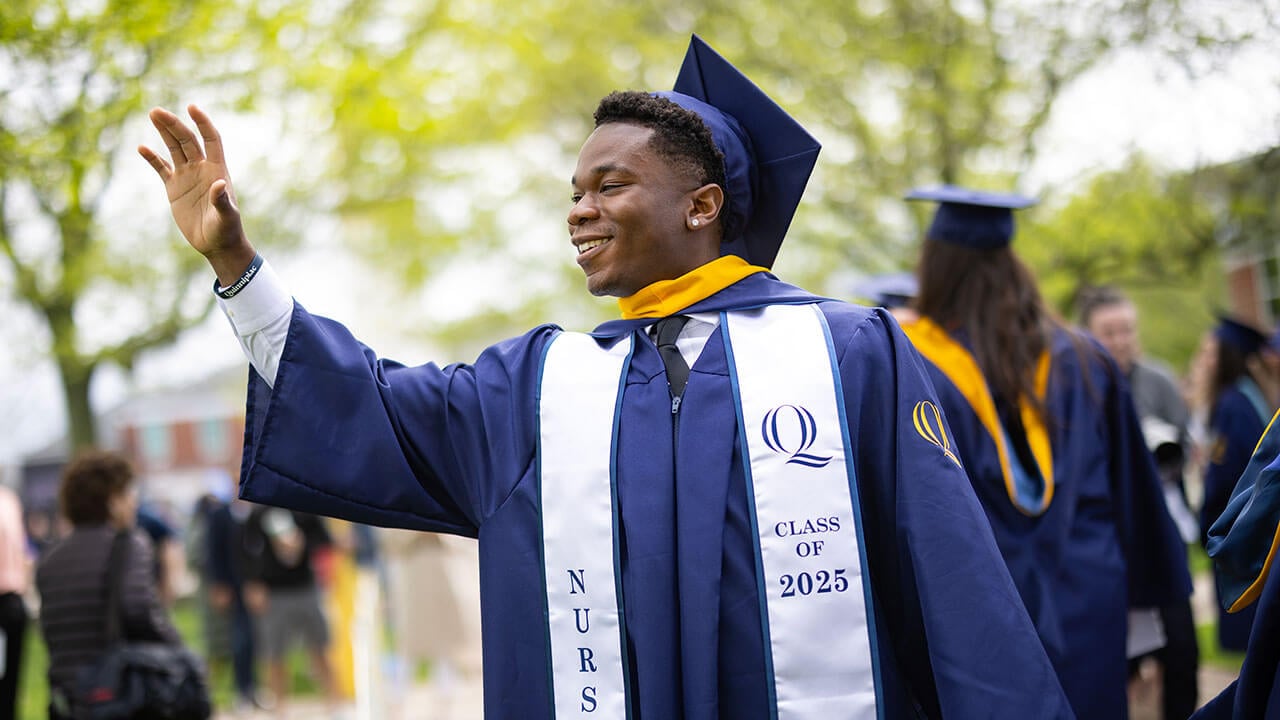 graduate waves to the crowd
