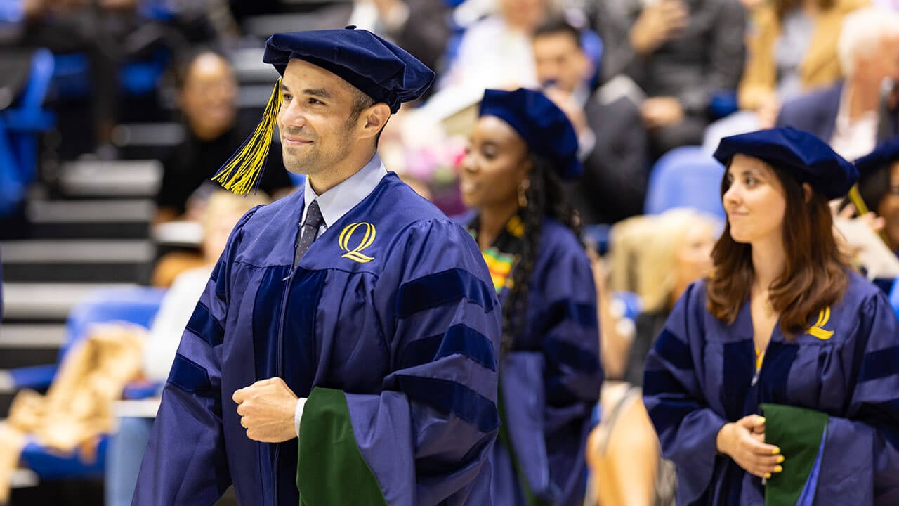 graduates line up with their hoods before going on stage