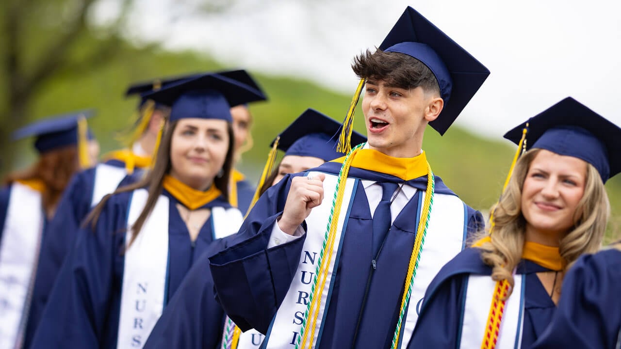 Student cheers as they process into commencement.