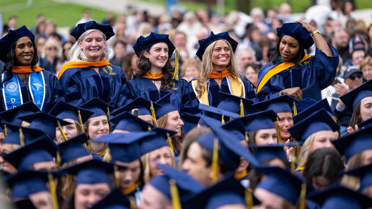 5 female DNP graduates standing in the crowd