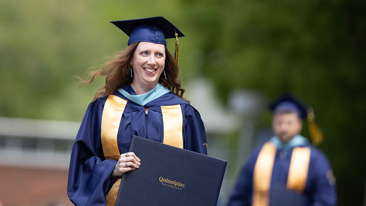 graduate smiles with diploma