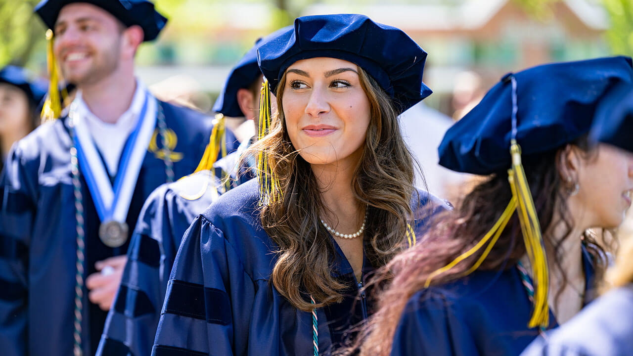 A graduate smiling into the distance