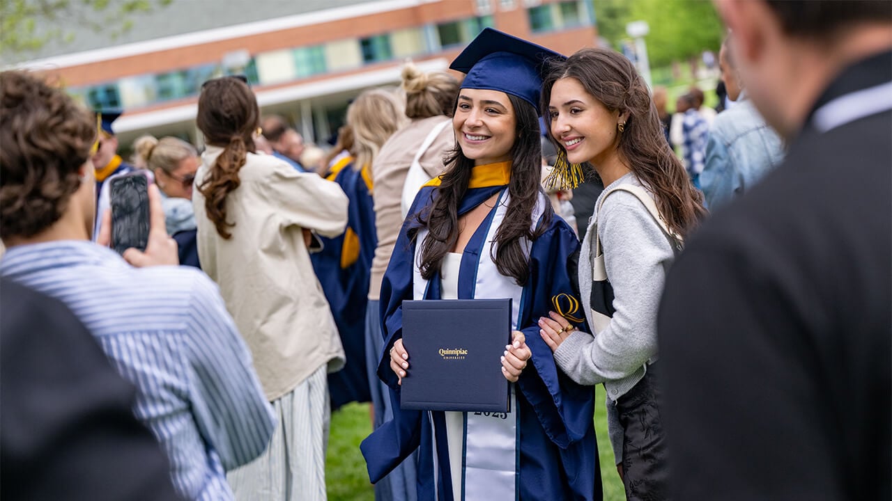 Female student poses with diploma.