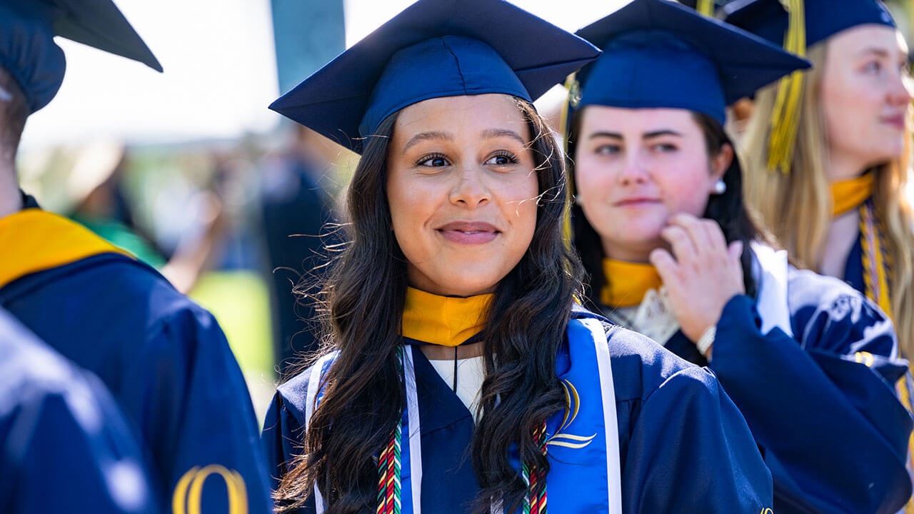 A graduate smiling into the distance