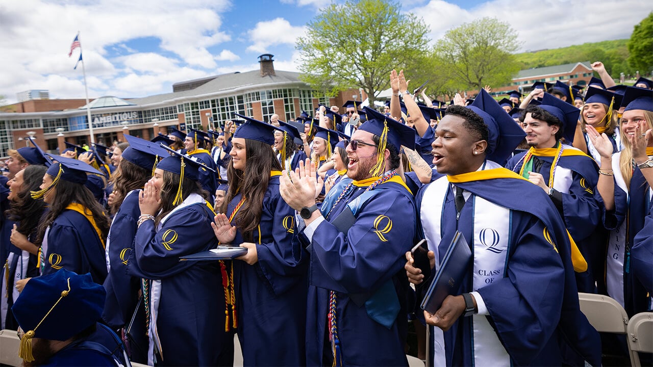 Graduating students cheering on the quad.