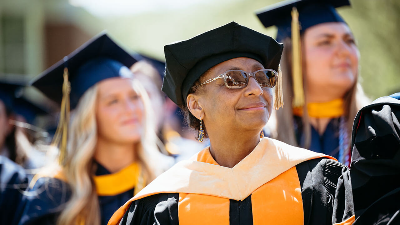 A Quinnipiac faculty member smiling into the distance
