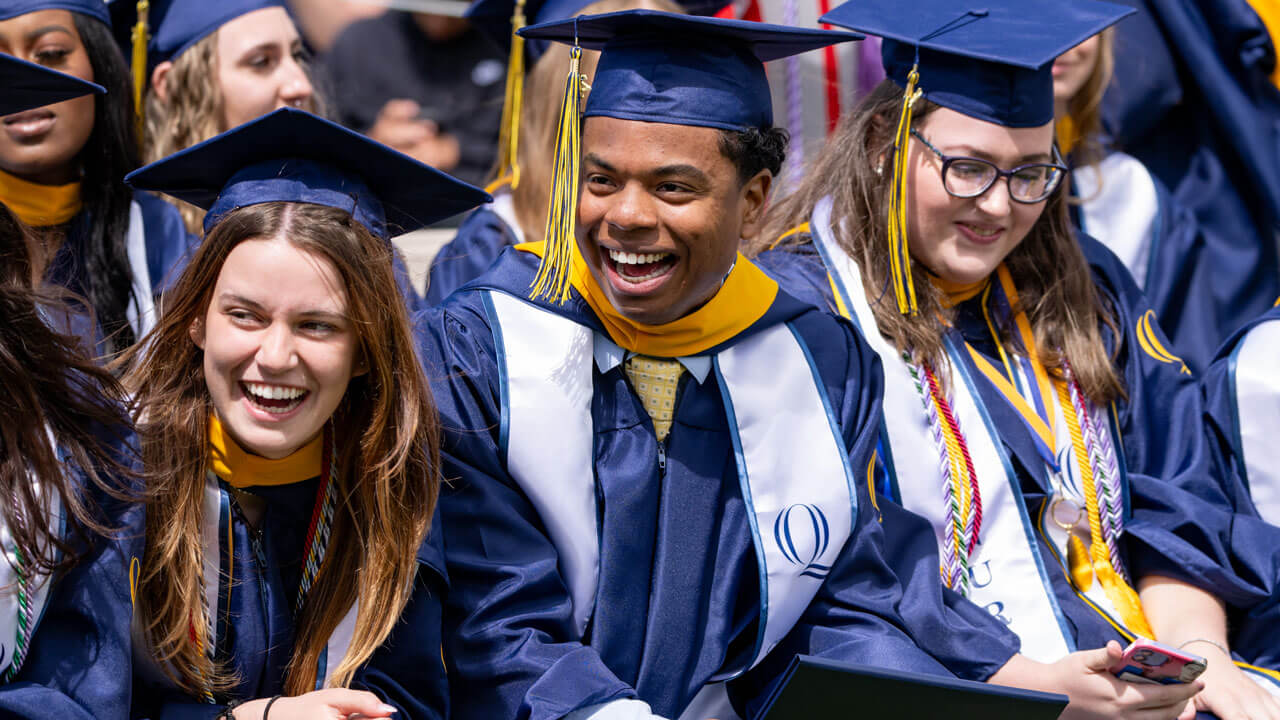 Graduates sit cheerfully during commencement speeches