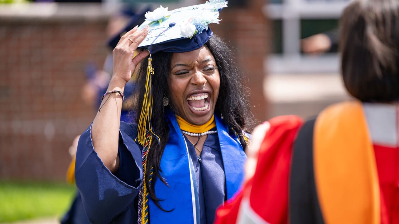 Graduate smiles enthusiastically