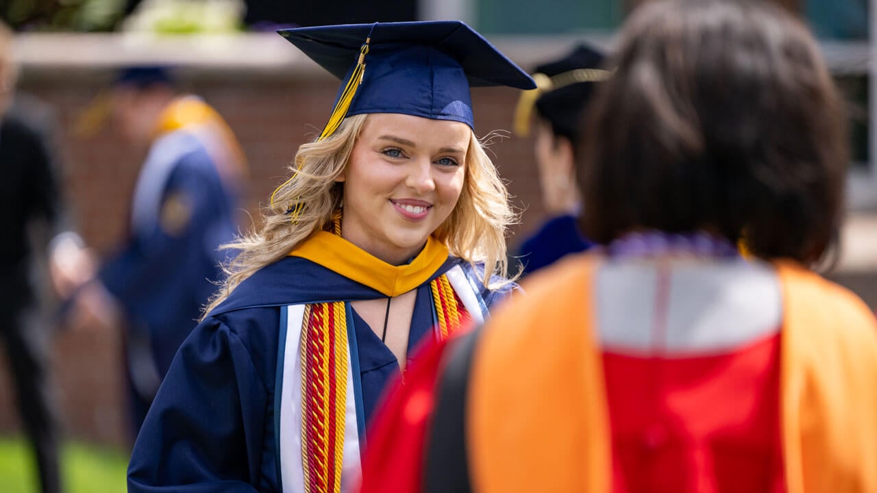 Graduate smiles enthusiastically