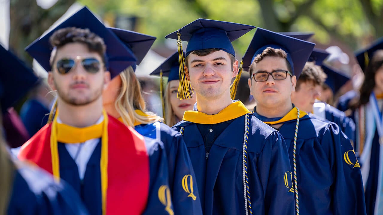 A graduate softly smiling into the distance