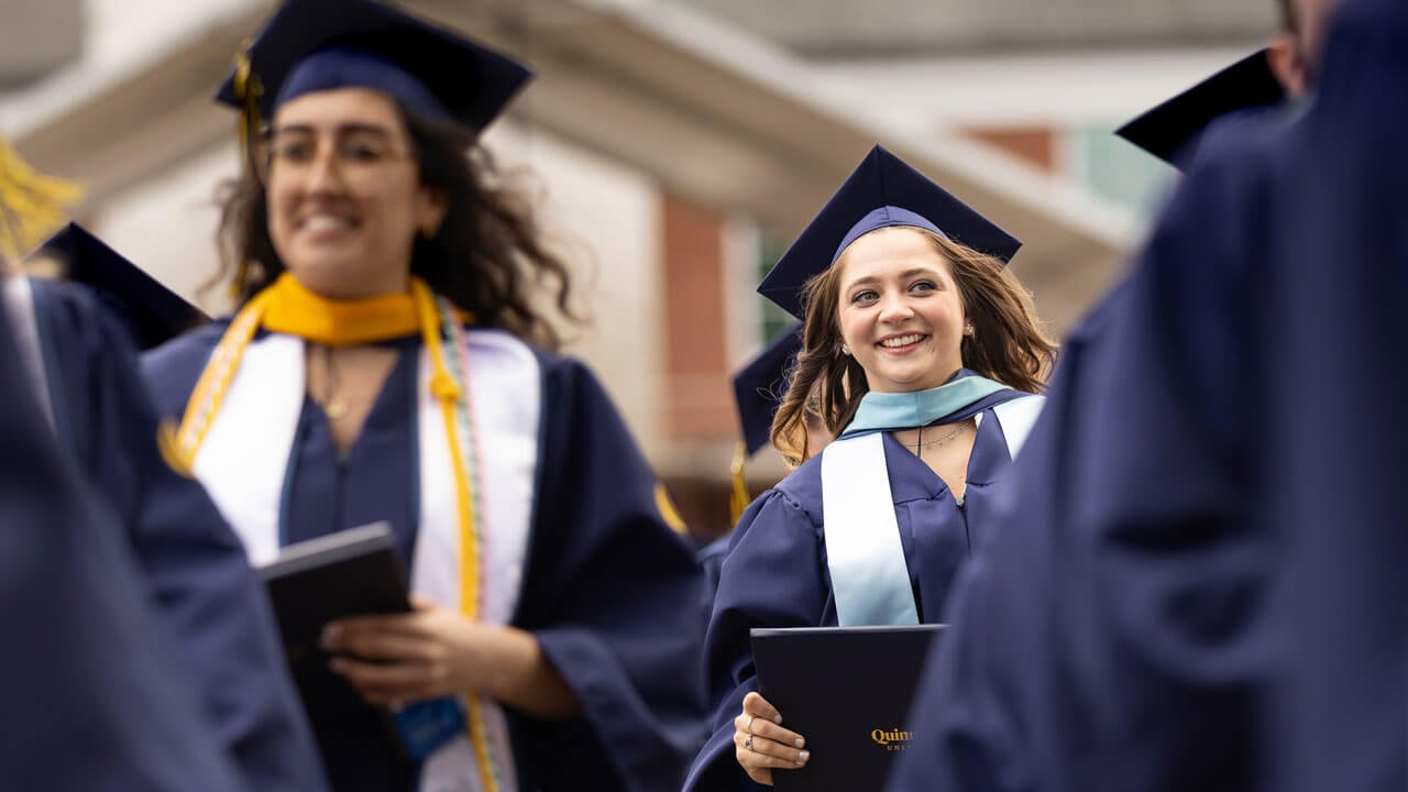 Graduate smiles while walking in procession