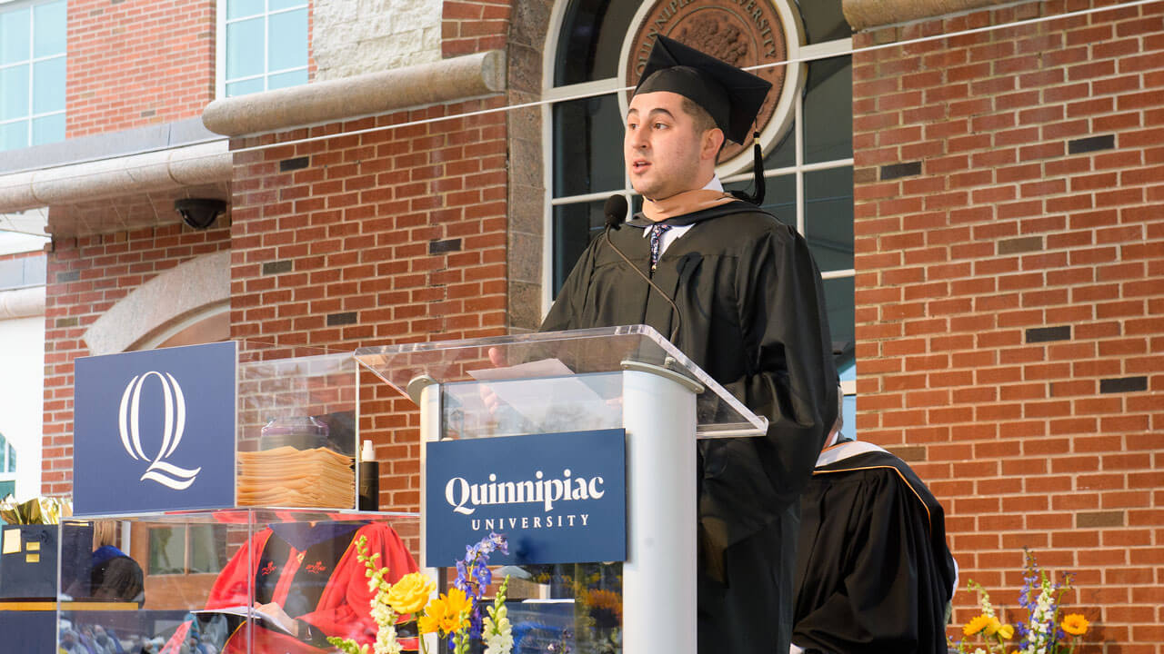 Sergio De La Espirella speaks to his fellow graduates from the library steps