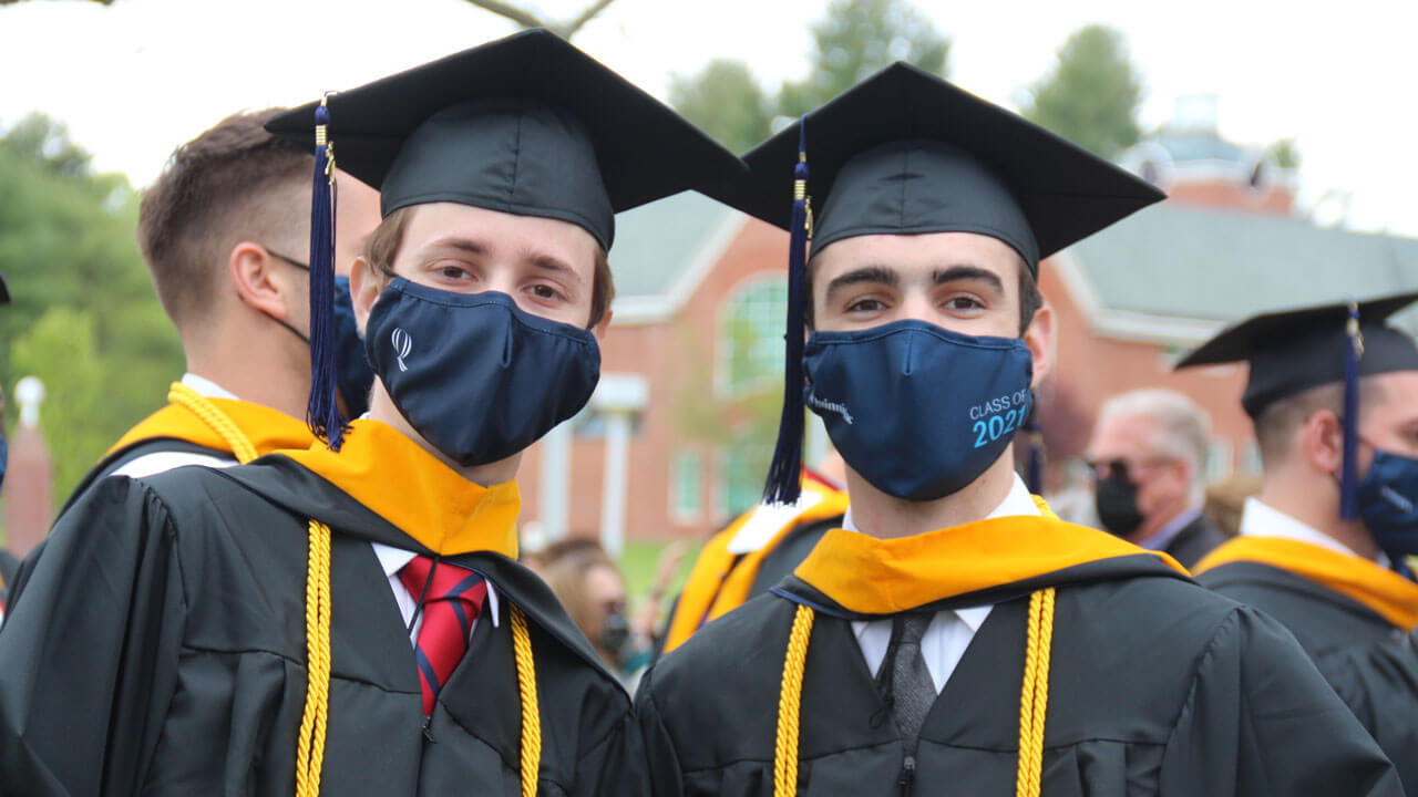 Two graduates pose together for a photo during Commencement