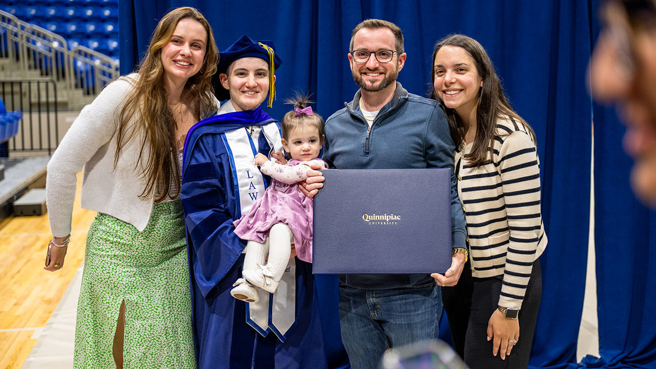 Graduate poses with their loved ones.