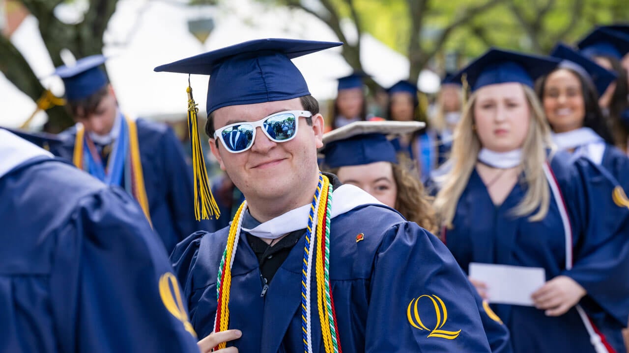 Graduate smiles while walking in procession