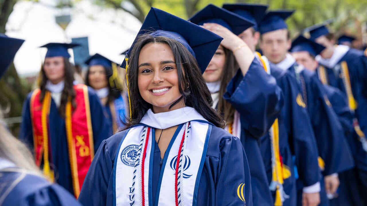 Graduate smiles while walking in procession