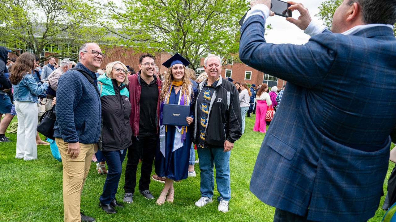 Graduate poses with their loved ones as they get their photo taken.