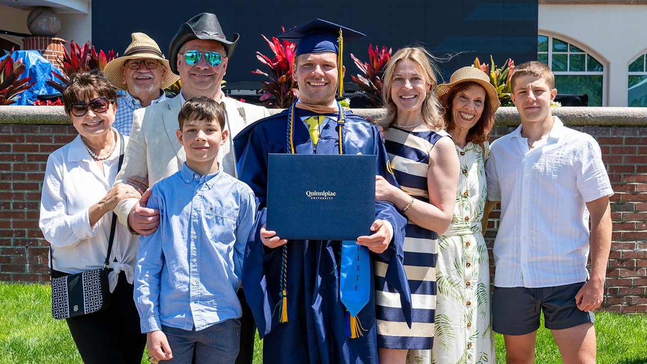 A graduate and seven friends and family members around them