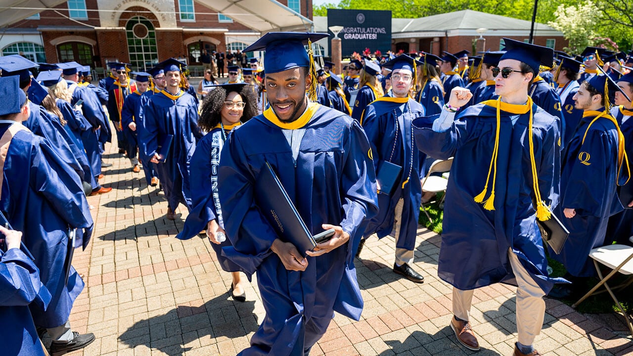 A graduate smiling after receiving their diploma
