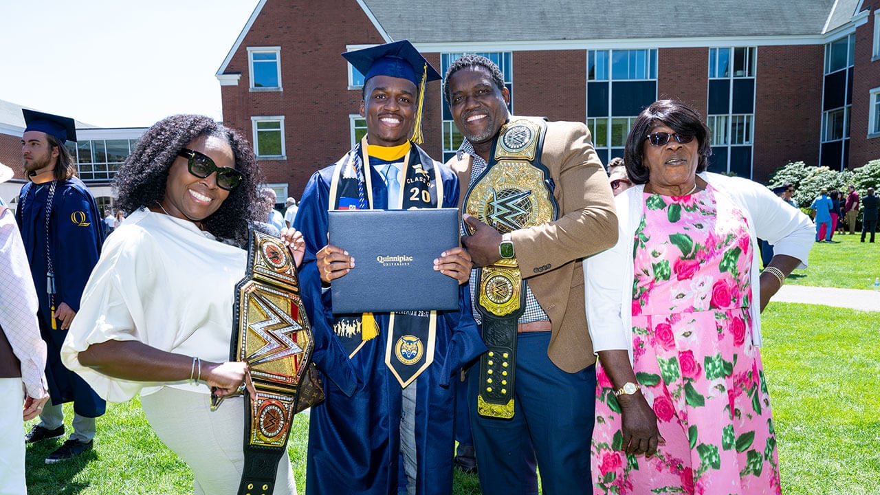 A graduate and three family members smiling as a group