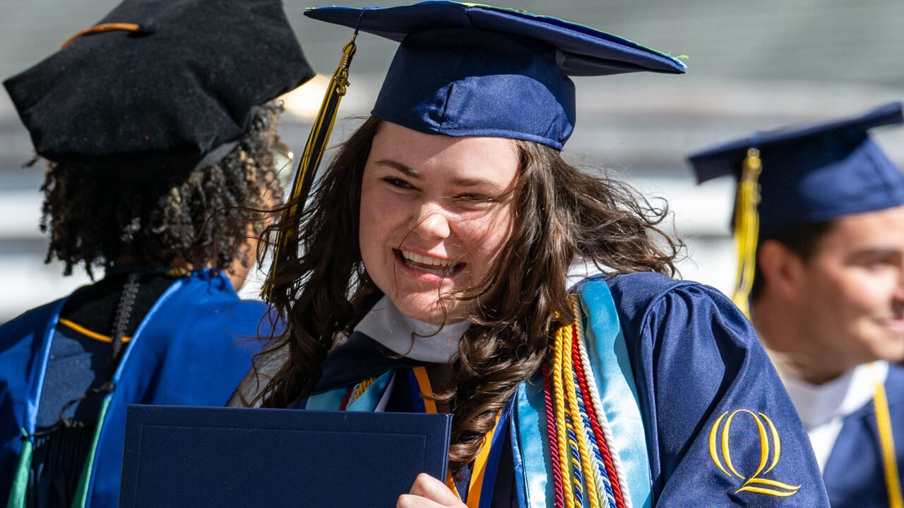 Emma Dinnan smiles as she walks off the commencement stage.