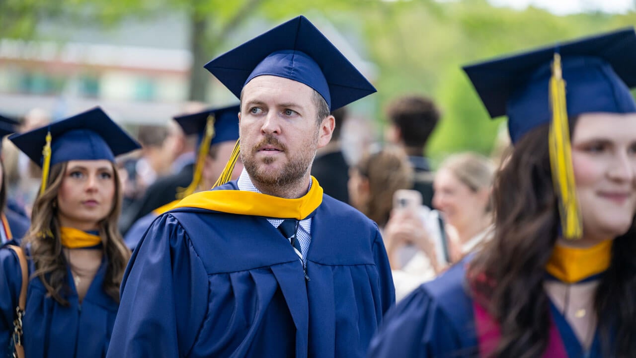 Chris Brodeur, Quinnipiac Writer and Editor, walks in procession