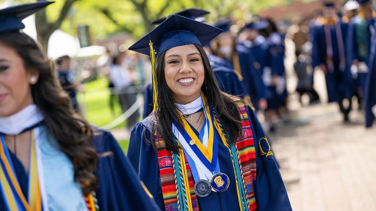 Graduate smiles while walking in procession