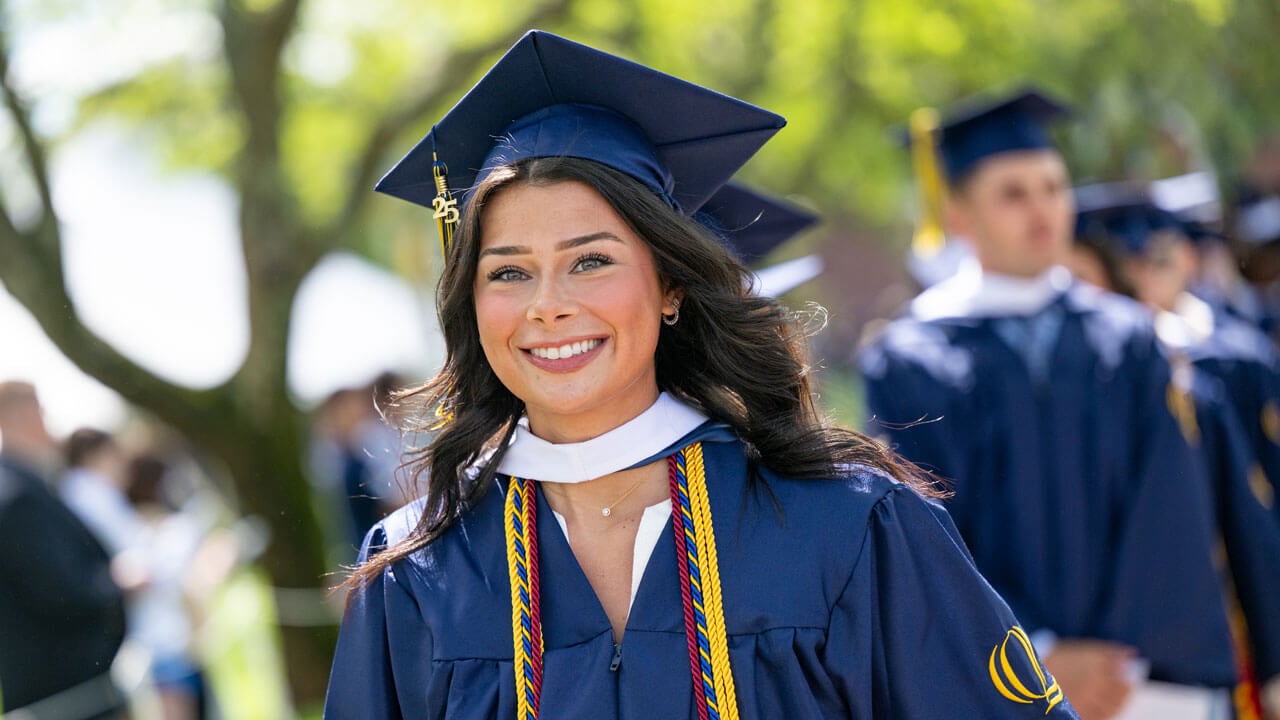 Graduate smiles while walking in procession