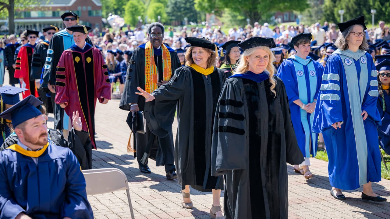 Several university administrators process into Commencement wearing doctoral robes