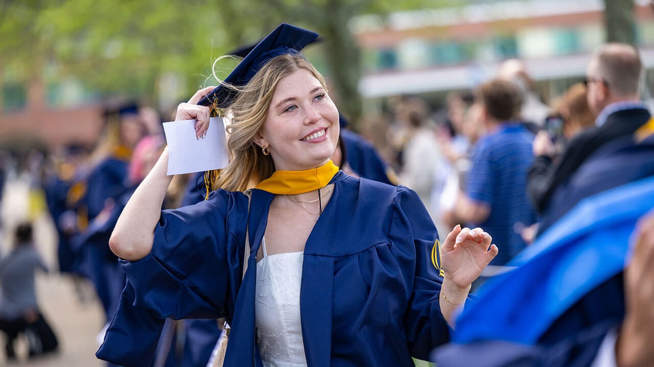 A grad smiling and looking into the distance