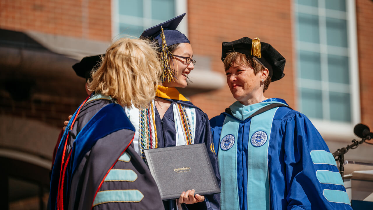 Monique Drucker smiles with her graduating daughter Madeleine as she receives her diploma