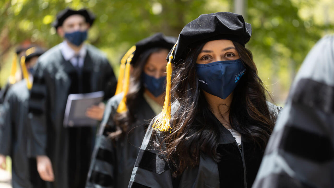 Medical school graduates walking into commencement ceremony