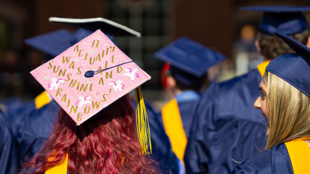 Graduates cap reads "it actually was all sunshine and rainbows."
