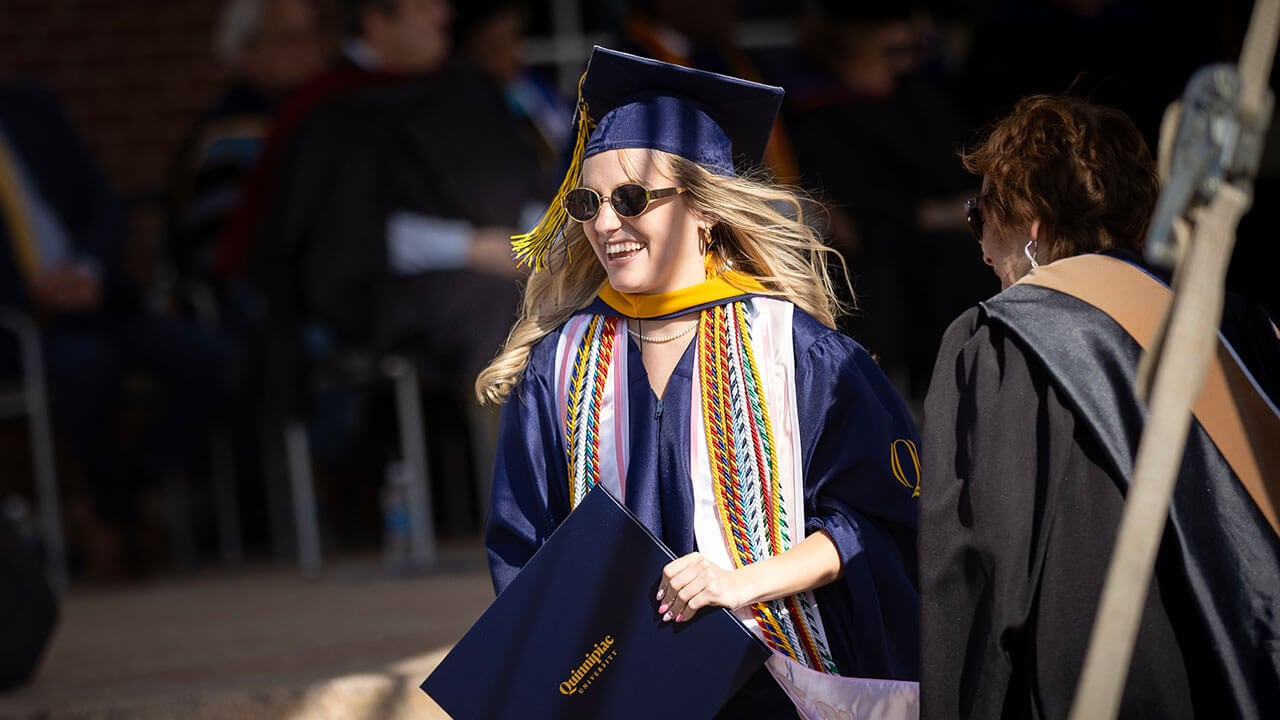 A graduate smiling as she walks off stage