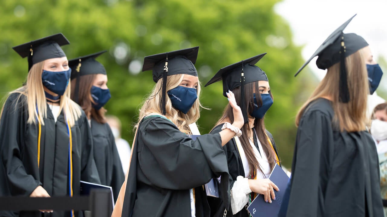 A graduate waves to a friend during Commencement
