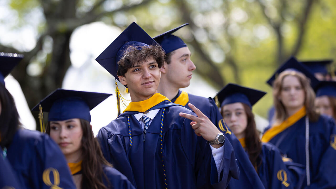 A grad holding up a peace sign