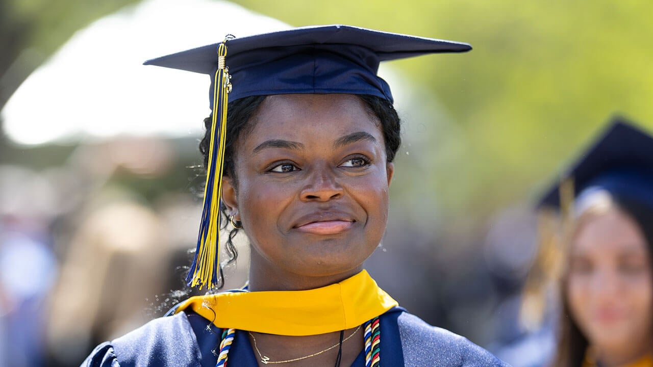 A graduate smiling into the distance