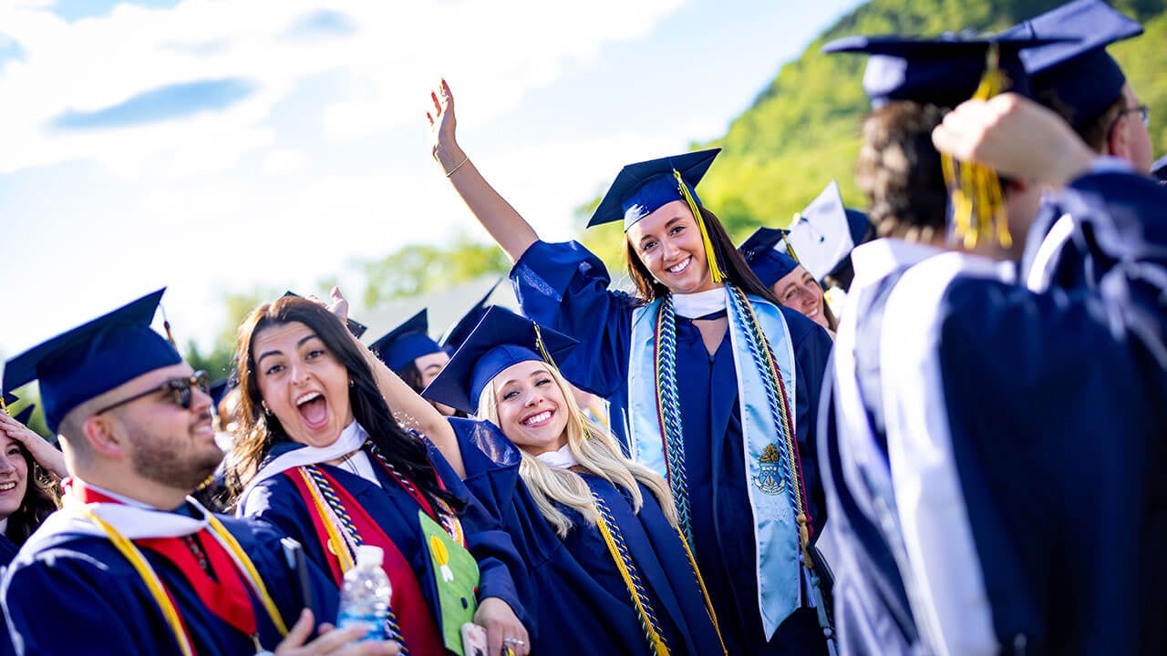 graduates wave and cheer to the camera