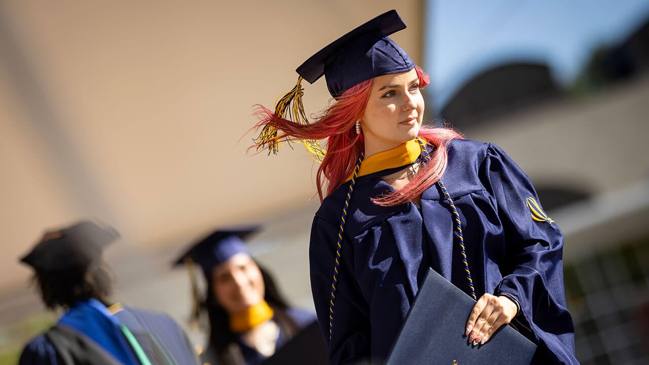 A graduate walks across the stage
