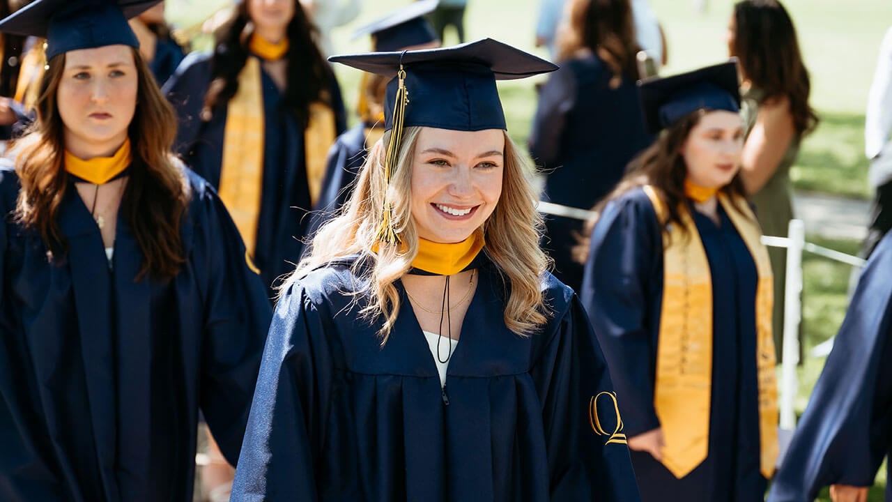 A grad smiling into the distance