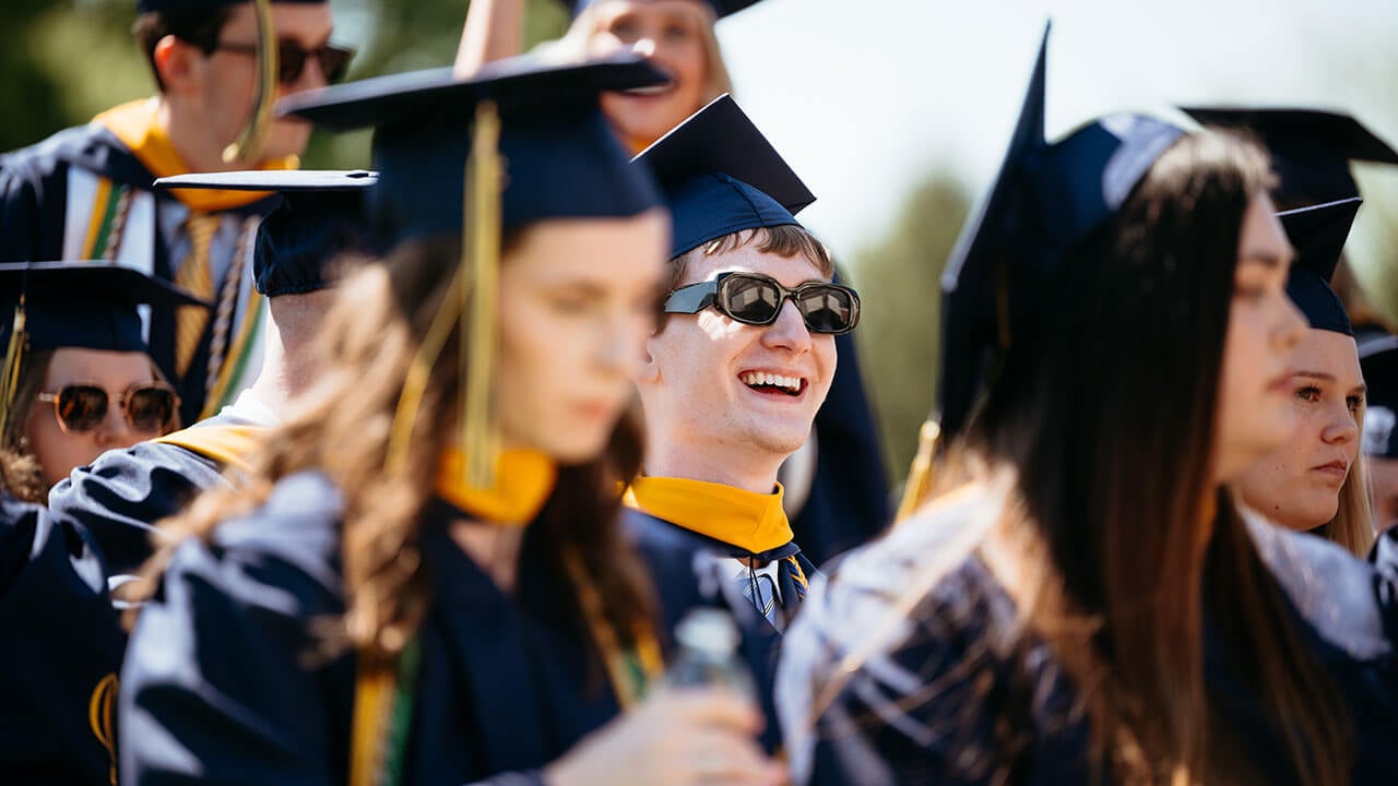A graduate laughing in the crowd