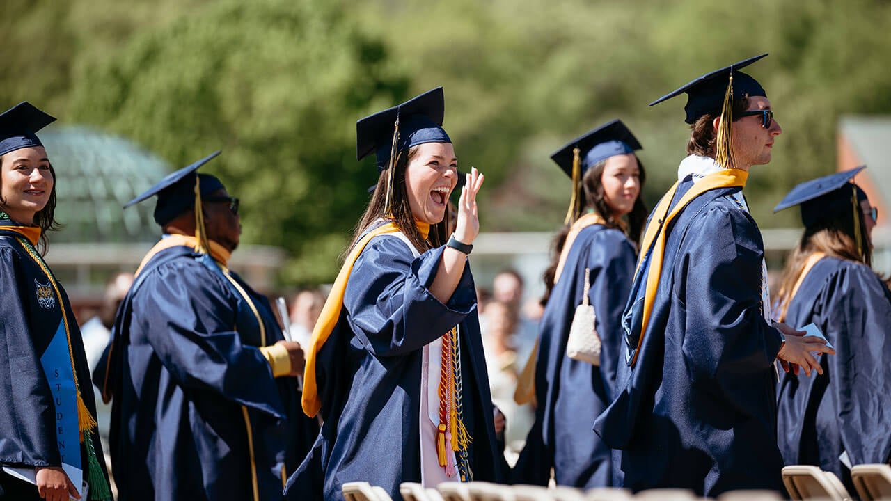 A grad excitedly waving into the distance