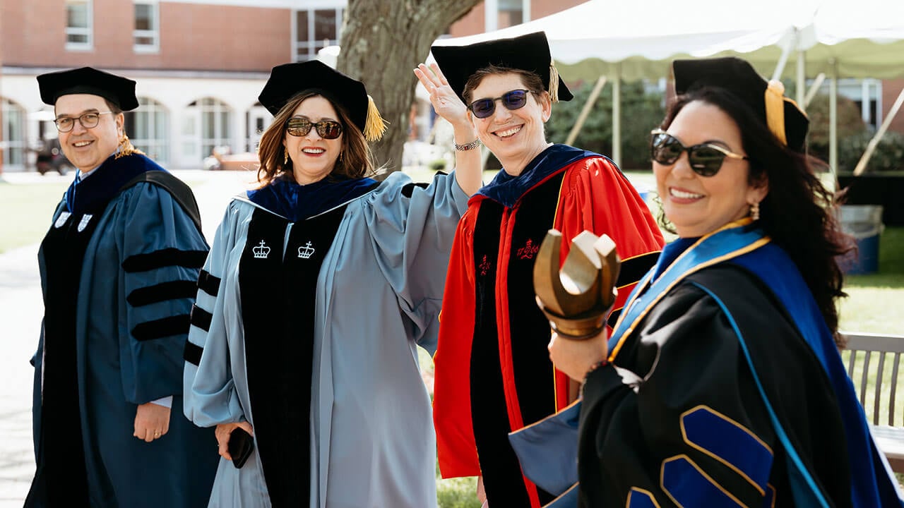 Dean Holly Raider, Provost Debra Liebowitz, and two others smile and wave.