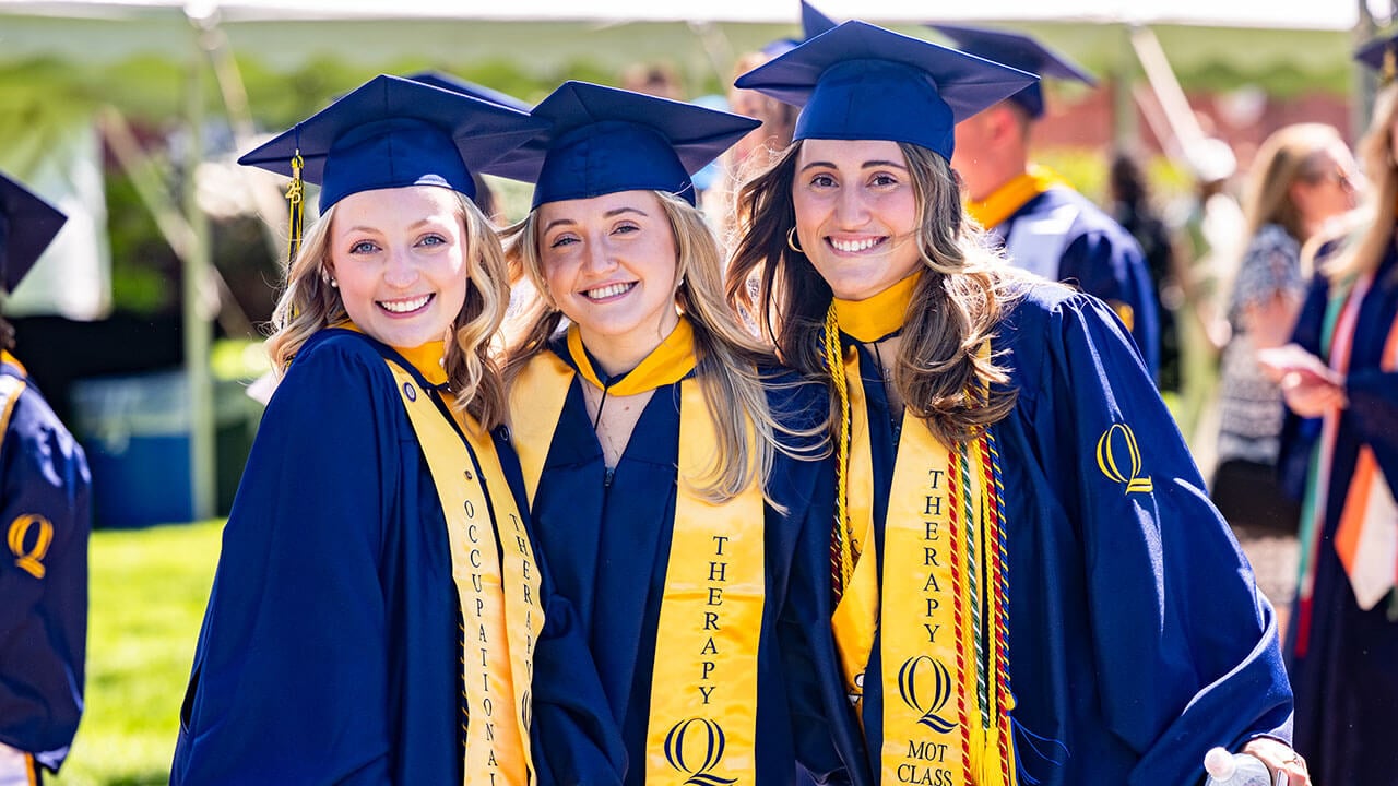 Three graduates smiling together