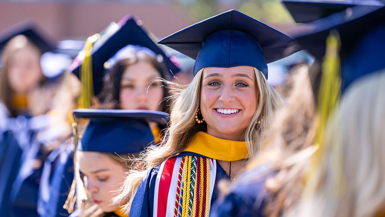 A graduate smiling widely