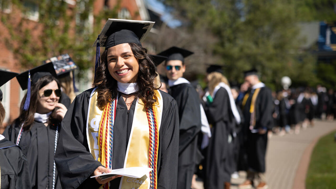 Graduate smiling waiting to line up for graduation ceremony